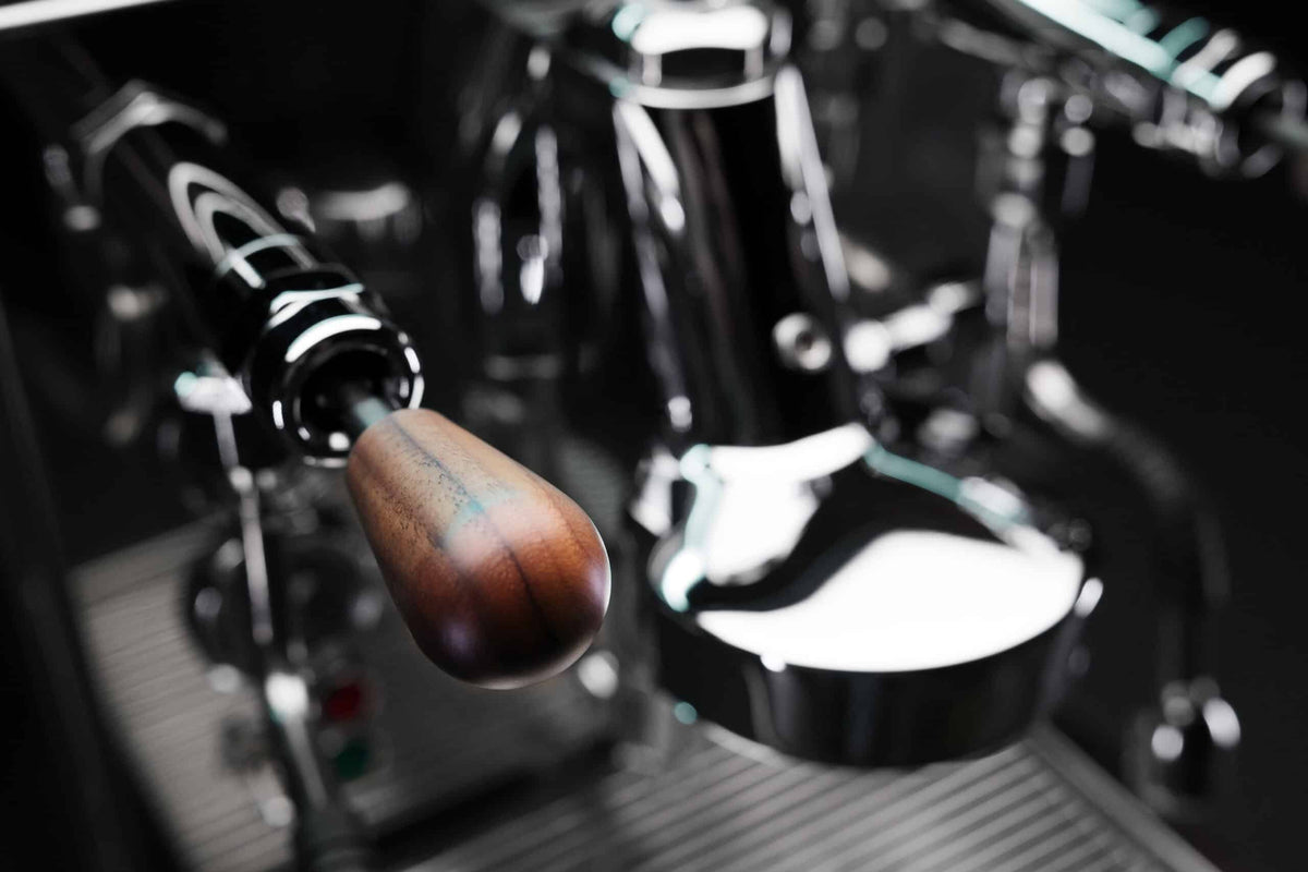 Close-up of the wooden portafilter handle on the MAKINA S7 Pro-PID group head